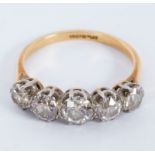 A diamond five-stone ring in a scroll setting, set in platinum to an 18ct yellow gold shank,