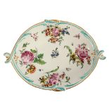 A Derby oval dish circa 1760, painted with flowers, the rims moulded as scrolls,
