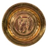 A Nuremberg brass alms dish, the centre embossed Adam, Eve and the Serpent,