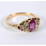 A ruby and diamond dress ring, the central oval ruby with three diamonds to each shoulder,