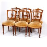 Six Victorian satin walnut dining chairs with pierced and carved backs and upholstered seats,