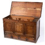 An oak chest with panelled front, fitted two drawers,