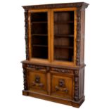 A carved oak bookcase with maskhead,
