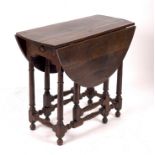 An oak two-flap oval gateleg table, fitted a drawer on turned tapered legs and stretchers,