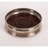 A George III silver wine coaster, London 1802, with beaded edge and pierced sides, crested,