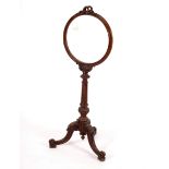 A Victorian walnut fire screen the circular frame with a ribbon-tie carved decoration,