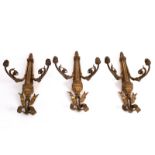 Three two-branch gilt metal wall lights, surmounted by ribbon-tie and with scrolling branches,