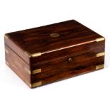 A Victorian rosewood and brass bound travel dressing case, the hinged cover enclosing a mirror,