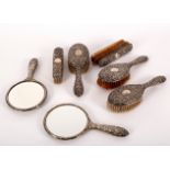 A quantity of silver-backed dressing table items, comprising three hairbrushes,