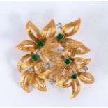 A gem set brooch by Cropp & Farr, of multiple flowerhead form interspersed by emeralds and diamonds,