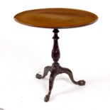 A mahogany table of 18th Century design, the dish top on a carved central column and tripod support,