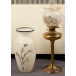 A brass oil lamp with opaque glass shade and a studio glass vase