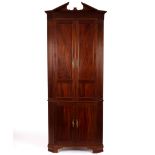 A mahogany corner cupboard with broken dentil cornice,