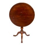 A George III mahogany table, the circular top on a birdcage action turned column and tripod base,