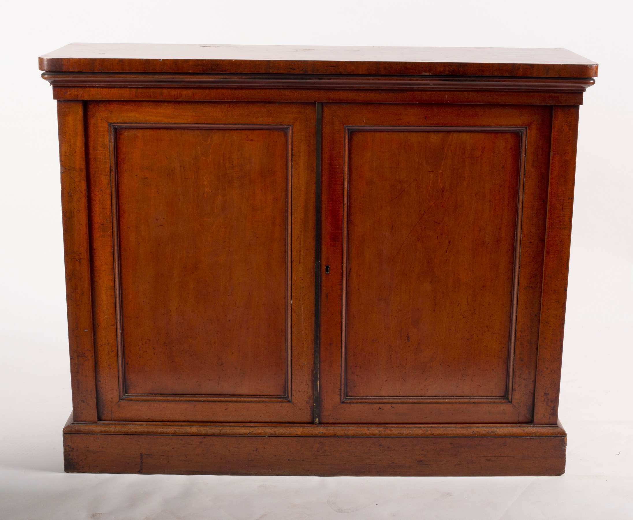 A Victorian mahogany side cabinet, enclosed by panel doors on a plinth base,