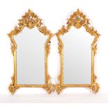 A pair of 18th Century style mirrors in gilded frames, the cartouche shaped plates 66cm x 34.