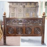 A 19th Century oak bed, the headboard with spindle wheels and galleries set a pair of sliding doors,