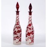 A pair of ruby and clear glass decanters and stoppers, 39.