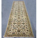 A Kashan runner with scrolling foliate design to an ivory field within a multiple border,