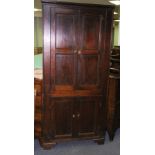 An early 19th Century oak corner cupboard enclosed by two pairs of panel doors, 91.