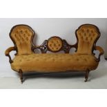 A Victorian walnut two chair back settee,