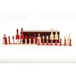 A mid-19th Century carved bone chess set in natural and red stain,