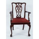 A mahogany armchair of 18th Century design with pierced upright splat and loose trap seat