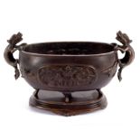 A Chinese oval censer with grotesque handles on a stand, 28.