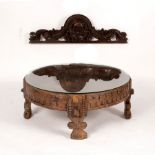 An Indian circular carved drum-top table on carved supports,