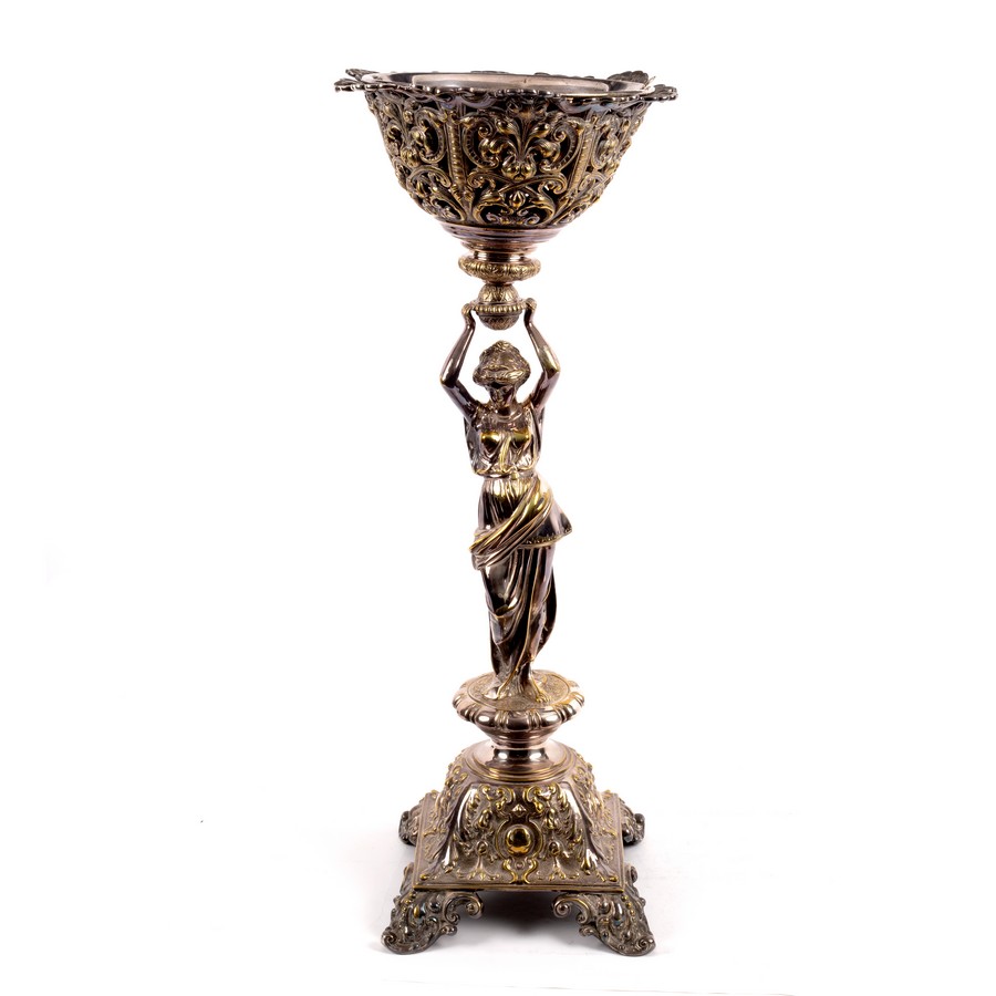 A silver plated table centrepiece modelled as a Classically draped female figure holding a basket