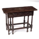 A carved oak side table, 17th Century and later, on gate-leg supports with moulded stretchers, 92.