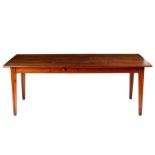 A French cherry wood farmhouse table, the planked top on square tapering legs, drawer to one side,