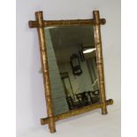 A wall mirror with a gilded simulated bamboo frame,