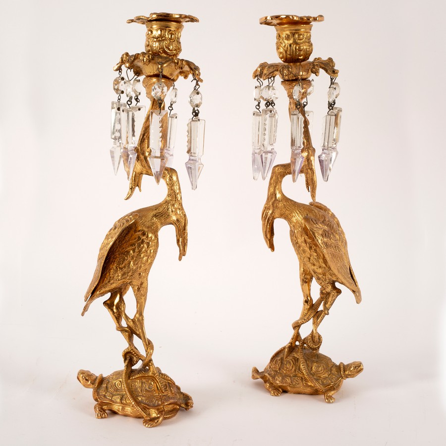 A pair of gilt metal figural candlesticks, each of a crane standing on a turtle,