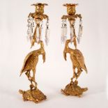 A pair of gilt metal figural candlesticks, each of a crane standing on a turtle,