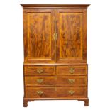 A George III mahogany linen press fitted for hanging with two short and two long drawers beneath,