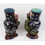 A pair of blue ground decorative vases each with stylised designs and a dragon in raised relief on