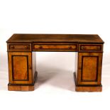 A breakfront kneehole desk by Lamb of Manchester, in burr elm with ebonised banding,