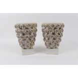 A pair of white glazed planters, each decorated with applied flowerheads,