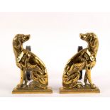 A pair of brass fire dogs, each modelled as a seated setter,