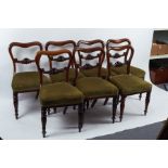 A set of seven Victorian buckle back dining chairs with upholstered seats on turned reeded front