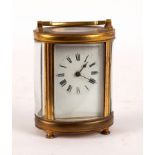 A carriage clock in an oval gilt brass case,