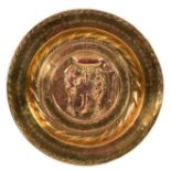 A Nuremberg brass alms dish, the centre embossed Adam, Eve and the serpent,