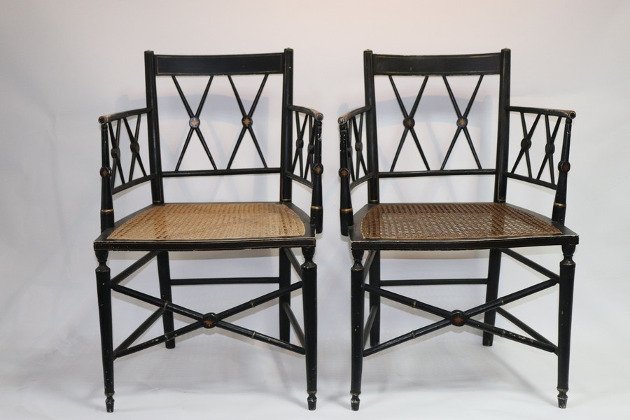 A pair of Regency ebonised cane seat armchairs with X shaped backs and turned arm supports and