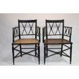 A pair of Regency ebonised cane seat armchairs with X shaped backs and turned arm supports and