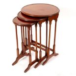 A nest of three mahogany circular tables with boxwood stringing on twin-turn end standards,