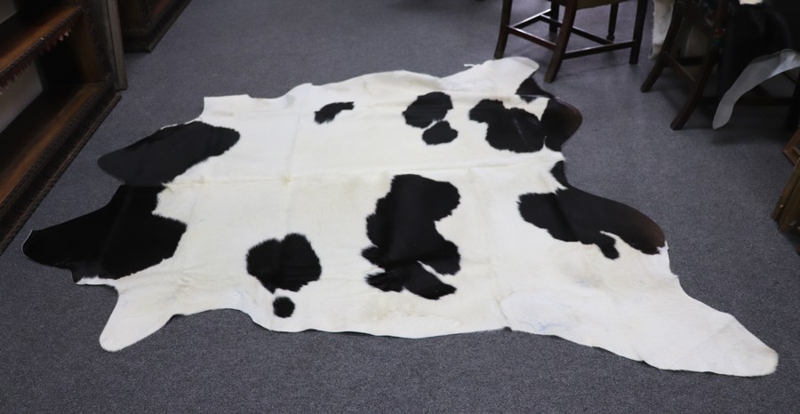 Two black and white hide skin rugs,