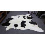 Two black and white hide skin rugs,