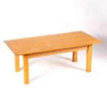 A bleached oak coffee table on square ash legs,