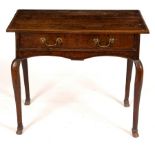 An 18th Century oak table, fitted one drawer and raised on cabriole legs with hoof feet,